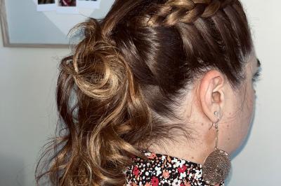 Miniature Hair by elle  #3 Femme de dos avec des cheveux blonds coiffés en tresse et chignon, portant un pull beige près d'une fenêtre.