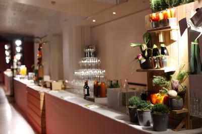 Buffet dressé dans une grande salle avec structure métallique, proposant boissons, viennoiseries et plats variés.