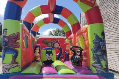 Miniature Le Rallye Loc #14 Structure gonflable jungle avec animaux et toboggan, entourée de feuilles, avec détails de location et caractéristiques.