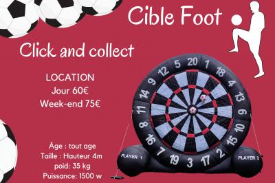 Un jeu de puissance 4 géant en bois placé sur une pelouse, à côté d'une girouette rouge sous des arbres.