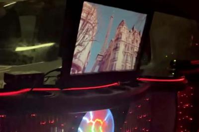 Limousine blanche sur une plateforme éclairée par des néons roses, avec texte ’Offre exclusive’ et prix affiché.