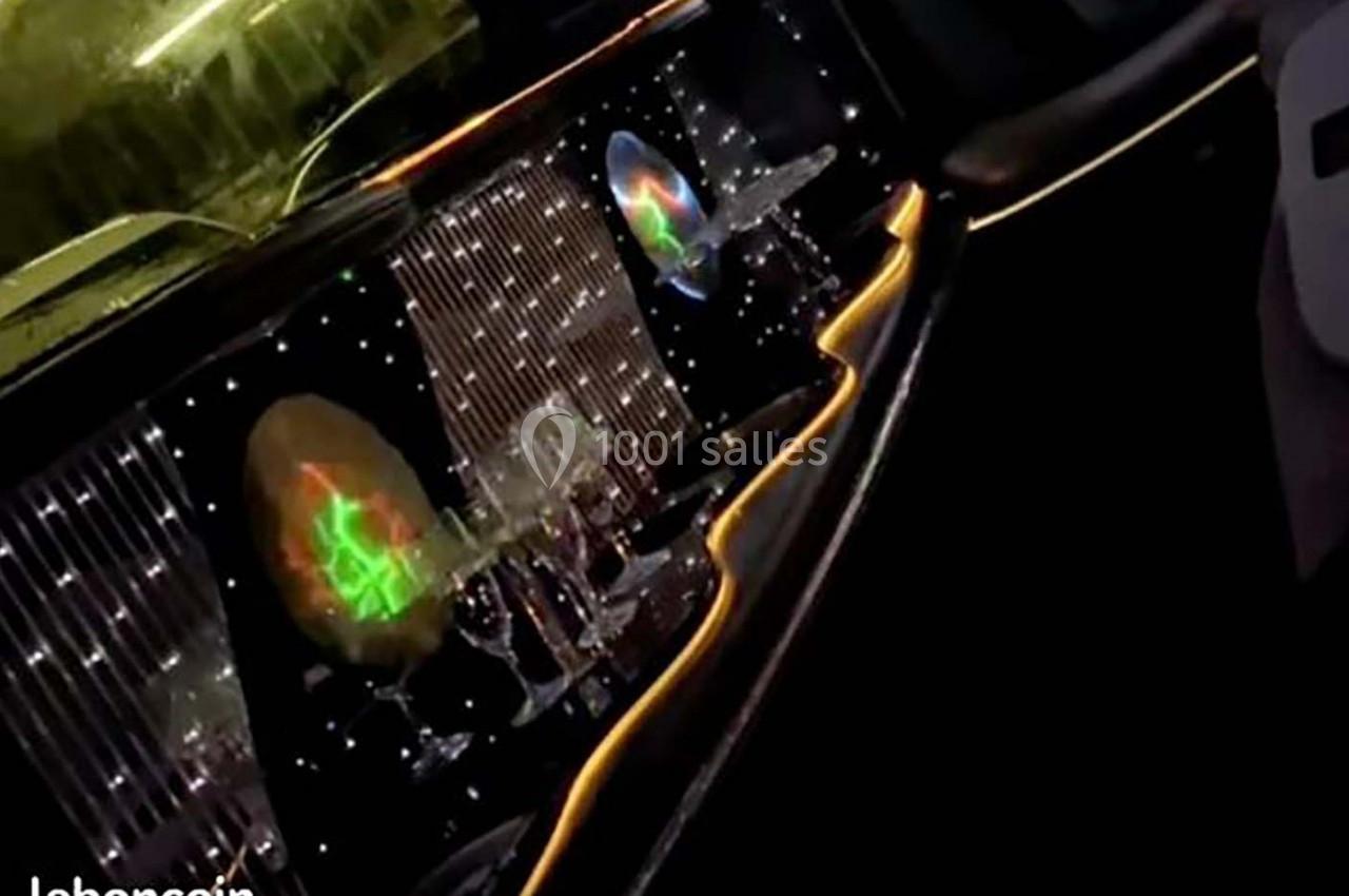 Intérieur d'une limousine avec des verres alignés, éclairage LED coloré et décorations lumineuses.