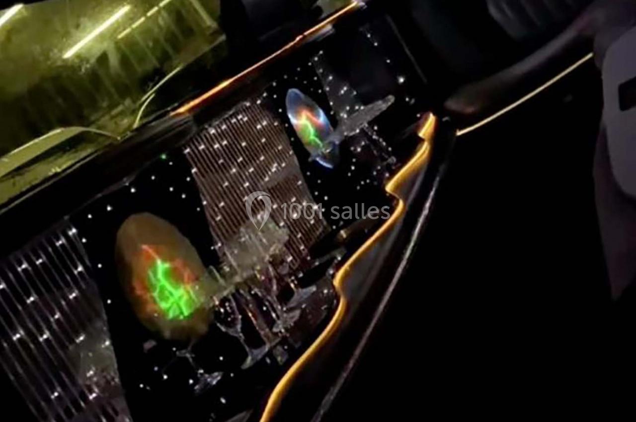 Intérieur d'une limousine avec éclairage LED coloré, verres à pied et décorations lumineuses sur les parois.