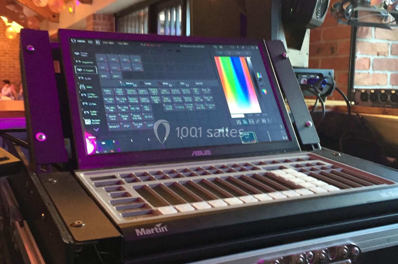 Console de contrôle d'éclairage avec écran tactile affichant des réglages colorimétriques, installée dans un espace…