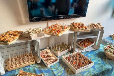 Des portions de nourriture servies dans des pots en carton avec des fleurs blanches en décoration.