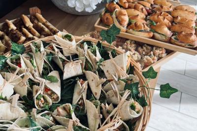 Des portions de nourriture servies dans des pots en carton avec des fleurs blanches en décoration.
