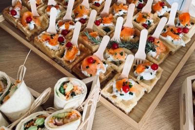 Des portions de nourriture servies dans des pots en carton avec des fleurs blanches en décoration.