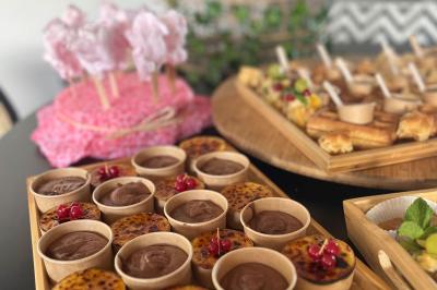 Des portions de nourriture servies dans des pots en carton avec des fleurs blanches en décoration.