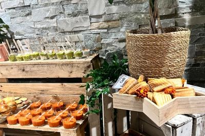 Des portions de nourriture servies dans des pots en carton avec des fleurs blanches en décoration.