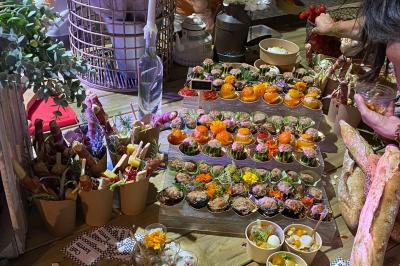 Des portions de nourriture servies dans des pots en carton avec des fleurs blanches en décoration.