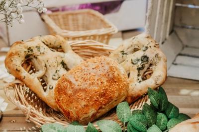 Des portions de nourriture servies dans des pots en carton avec des fleurs blanches en décoration.