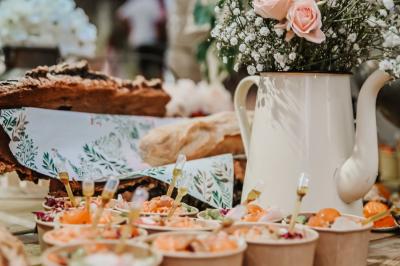 Des portions de nourriture servies dans des pots en carton avec des fleurs blanches en décoration.