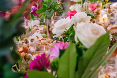 Des portions de nourriture servies dans des pots en carton avec des fleurs blanches en décoration.