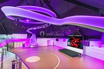 Piscine éclairée de nuit entourée de chaises longues, avec une terrasse en premier plan et des bougies allumées.