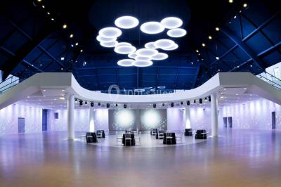 Piscine éclairée de nuit entourée de chaises longues, avec une terrasse en premier plan et des bougies allumées.