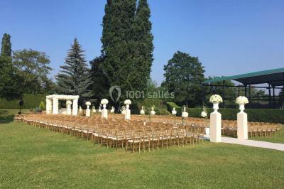 Piscine éclairée de nuit entourée de chaises longues, avec une terrasse en premier plan et des bougies allumées.