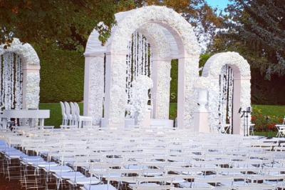 Piscine éclairée de nuit entourée de chaises longues, avec une terrasse en premier plan et des bougies allumées.