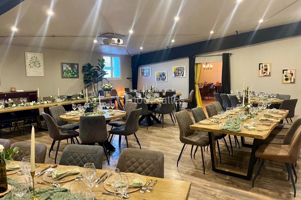 Salle de réception élégamment décorée avec des tables dressées, des chaises rembourrées et des œuvres d'art accrochées aux…