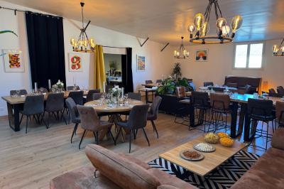 Coucher de soleil rougeoyant derrière une rangée d'arbres, vu depuis une terrasse avec mobilier et voitures garées.