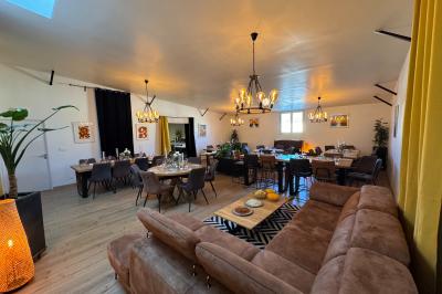 Coucher de soleil rougeoyant derrière une rangée d'arbres, vu depuis une terrasse avec mobilier et voitures garées.