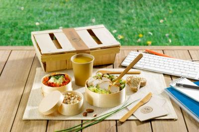 Plateau de légumes croquants, dips et charcuterie disposés sur une table en extérieur, avec des décorations végétales.