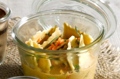 Plateau de légumes croquants, dips et charcuterie disposés sur une table en extérieur, avec des décorations végétales.