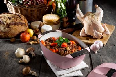 Plateau de légumes croquants, dips et charcuterie disposés sur une table en extérieur, avec des décorations végétales.