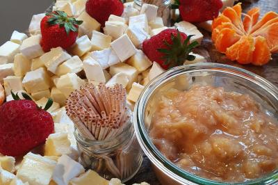 Plateau de légumes croquants, dips et charcuterie disposés sur une table en extérieur, avec des décorations végétales.