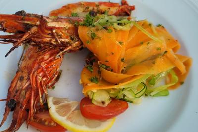 Plateau de légumes croquants, dips et charcuterie disposés sur une table en extérieur, avec des décorations végétales.
