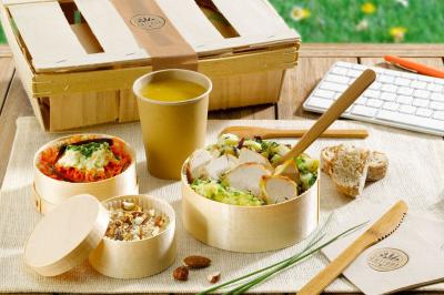 Plateau de légumes croquants, dips et charcuterie disposés sur une table en extérieur, avec des décorations végétales.