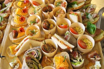 Plateau de légumes croquants, dips et charcuterie disposés sur une table en extérieur, avec des décorations végétales.