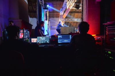 Miniature DJ Béziers (Hérault) - Jean-Charles Sound Designer #21 Façade d'un bâtiment illuminée par des projections lumineuses colorées dans un environnement nocturne.