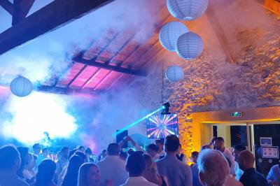 Façade d'un bâtiment illuminée par des projections lumineuses colorées dans un environnement nocturne.