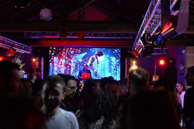 Façade d'un bâtiment illuminée par des projections lumineuses colorées dans un environnement nocturne.