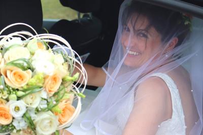 Miniature Lucy DT Photos #4 Femme en peignoir blanc se maquillant devant un miroir, ses cheveux ornés de petites fleurs blanches.