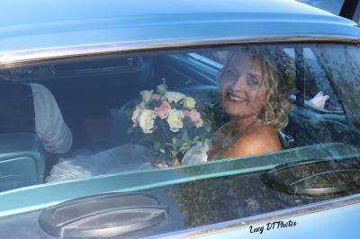 Miniature Lucy DT Photos #2 Femme en peignoir blanc se maquillant devant un miroir, ses cheveux ornés de petites fleurs blanches.