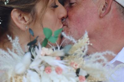 Miniature Lucy DT Photos #12 Femme en peignoir blanc se maquillant devant un miroir, ses cheveux ornés de petites fleurs blanches.