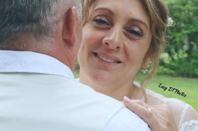 Miniature Lucy DT Photos #15 Femme en peignoir blanc se maquillant devant un miroir, ses cheveux ornés de petites fleurs blanches.