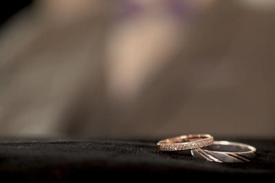 Miniature Vidéo Studio Andy LTH #7 Deux alliances en métal, dont une ornée de petits diamants, posées sur un tissu noir avec un fond flou.