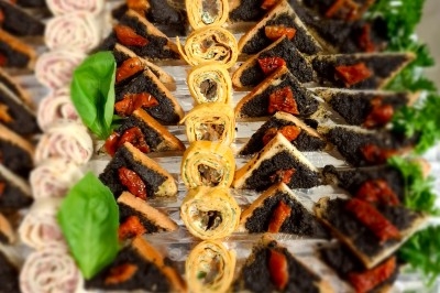 Salle décorée avec rideaux bleus, guirlandes lumineuses, vases avec fleurs et table recouverte d'une nappe blanche.