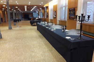Salle de restaurant avec longues tables dressées, éclairage tamisé et effets lumineux colorés sur le sol.