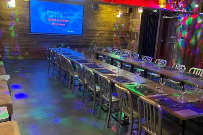 Miniature Traiteur Saint-Priest (Rhône) - Le Séraphin Traiteur #7 Salle de restaurant avec longues tables dressées, éclairage tamisé et effets lumineux colorés sur le sol.