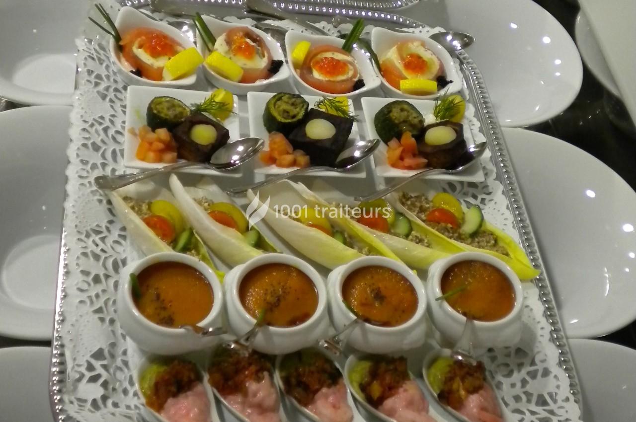 Plateau de verrines et amuse-bouches variés, disposés sur un plateau argenté avec des cuillères individuelles.