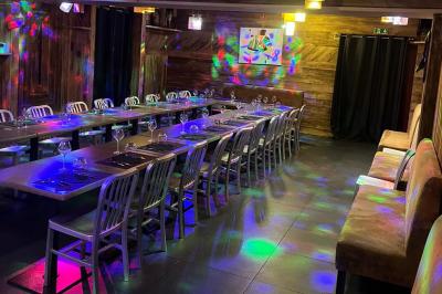 Miniature Traiteur Saint-Priest (Rhône) - Le Séraphin Traiteur #14 Salle de restaurant avec longues tables dressées, éclairage tamisé et effets lumineux colorés sur le sol.