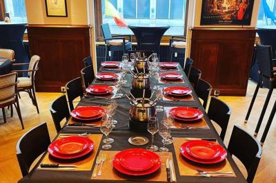 Miniature Location salle Bruxelles (Bruxelles-Capitale) - La Salle Montoyer Bruxelles #8 Salle de réception lumineuse avec tables rondes dressées, chaises blanches et éclairage violet au plafond.