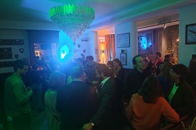 Miniature Location salle Bruxelles (Bruxelles-Capitale) - La Salle Montoyer Bruxelles #10 Salle de réception lumineuse avec tables rondes dressées, chaises blanches et éclairage violet au plafond.