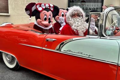 Salle de réception décorée avec des tables rondes, nappes blanches, éclairage rouge et arrangements floraux suspendus.