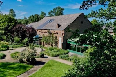 Miniature Location salle Somme-Leuze (Namur) - Ferme de l'Abbaye de Hogne #3 Vue d'un parc verdoyant avec des arbres, une pelouse et une rivière au premier plan, sous un ciel clair.