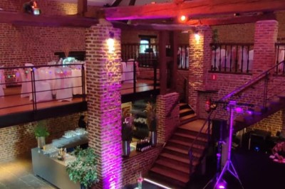 Tente éclairée par des guirlandes lumineuses dans un jardin verdoyant au crépuscule.