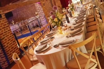 Tente éclairée par des guirlandes lumineuses dans un jardin verdoyant au crépuscule.